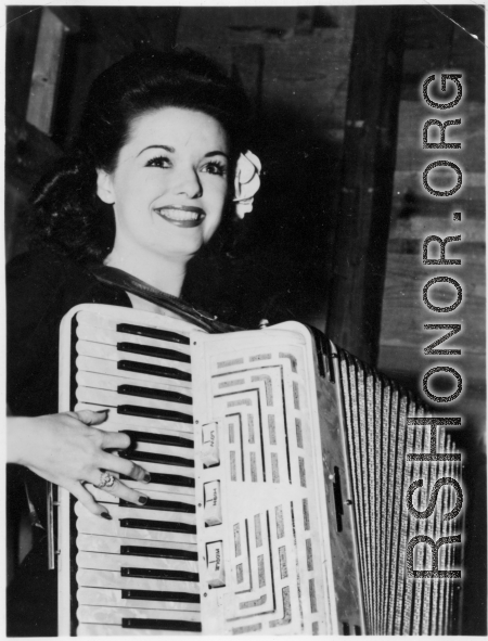 Celebrities visit and perform at Yangkai, Yunnan province, during WWII: Ruth Dennis poses with the accordion.