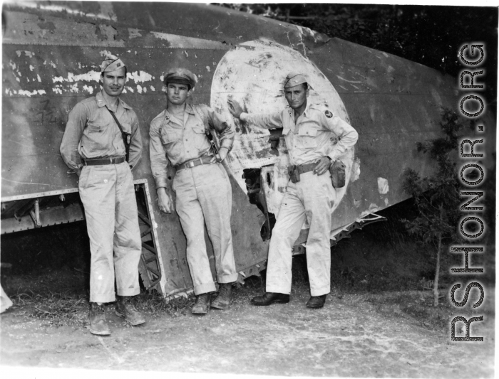 GIs pose against downed aircraft wing. The middle person might be Maj Richard D. Day (李察戴).