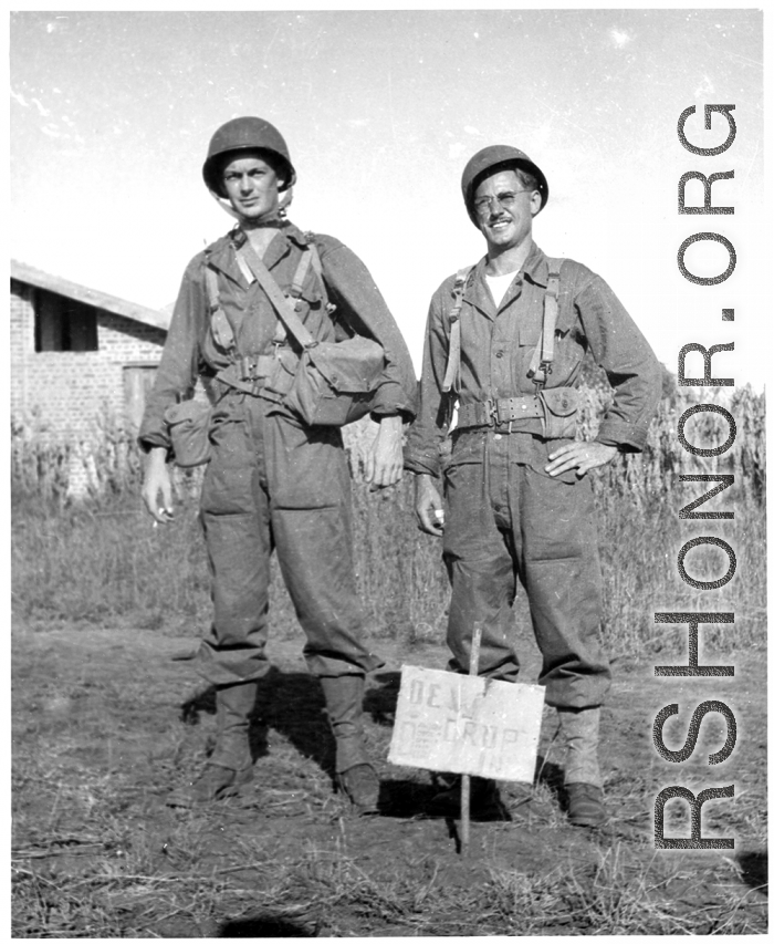 Two GIs in combat gear, either in in China, or possibly at Camp Swift, Texas during training. During WWII.  Curiously, the sign in the ground in front of them says "Dew Drop In."