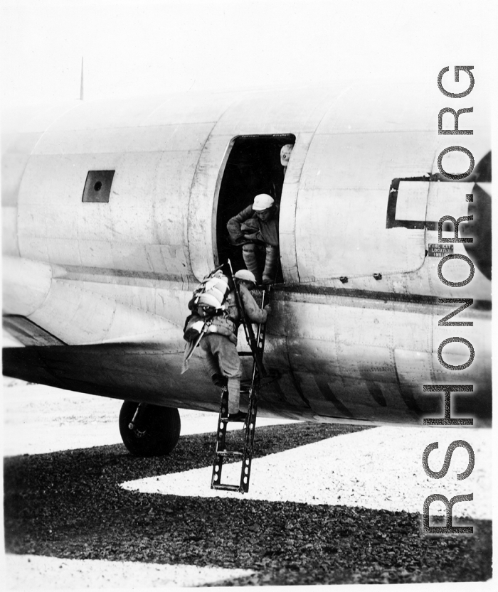 Chinese soldiers climb down ladder out of C-46 transport plane. During WWII.