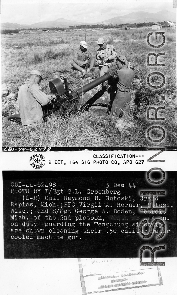 Cpl. Raymond B. Gutoski, Pfc. Virgil A. Horner, S/Sgt. George A. Boden, of 2nd Platoon, 704th AB AAA Battalion, on duty guarding the Tengchong airstrip, are shown cleaning their .50 caliber water-cooled machine gun.  Yunnan Province on December 5, 1944.  Photo by T/Sgt. S. L. Greenberg.  Passed by censor Samuel Goldberg.