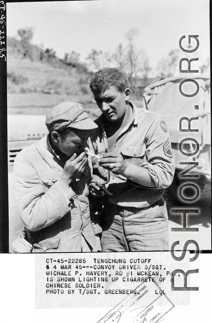 At the Tengchong cutoff: Convoy driver S/Sgt. Michale P. Havery, is shown lighting up cigarette of a Chinese soldier.  Yunnan Province on March 4, 1945.  Photo by T/Sgt. Greenberg.  Passed by William E. Whitten.