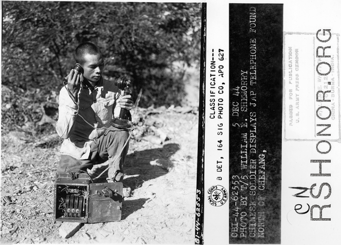 Chinese soldier displays Japanese telephone found north of Zhefang.  December 5, 1944.  Photo by T/5 William E. Shemorry. 164th Signal Photographic Company, APO 627.  Passed by William E. Whitten.