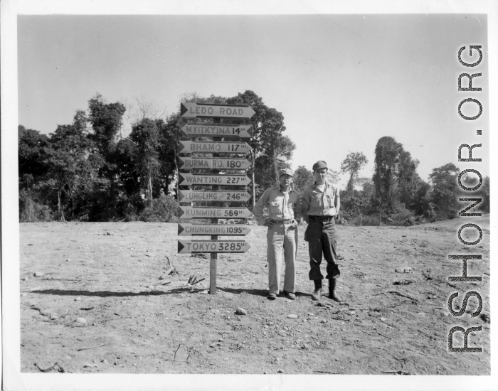 GIs pose before road sign on Burma Road.  797th Engineer Forestry Company.  During WWII.