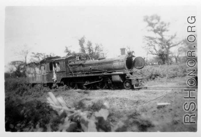 A shot up steam railroad engine, showing large number of bullet or shrapnel holes, derelict in Burma.  During WWII.  797th Engineer Forestry Company.