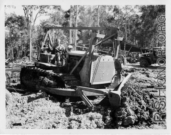 Bulldozer pushing dirt in Burma.  797th Engineer Forestry Company in Burma.  During WWII.