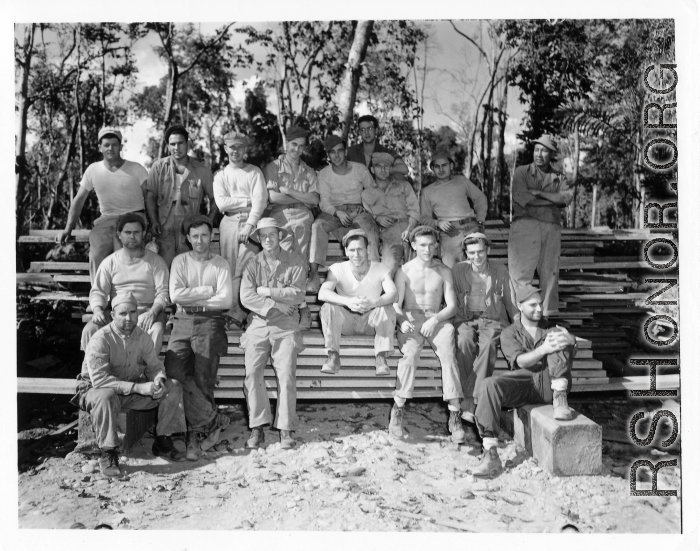 Engineers of the 797th Engineer Forestry Company pose outside on stack of sawn lumber at a camp in Burma.  During WWII.