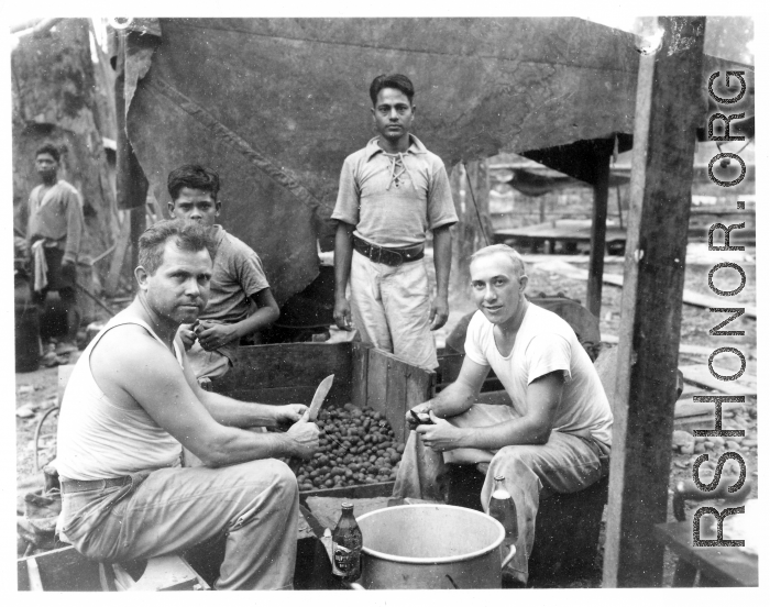 Engineers of the 797th Engineer Forestry Company skin potatoes in KP duty at a camp in Burma. During WWII.
