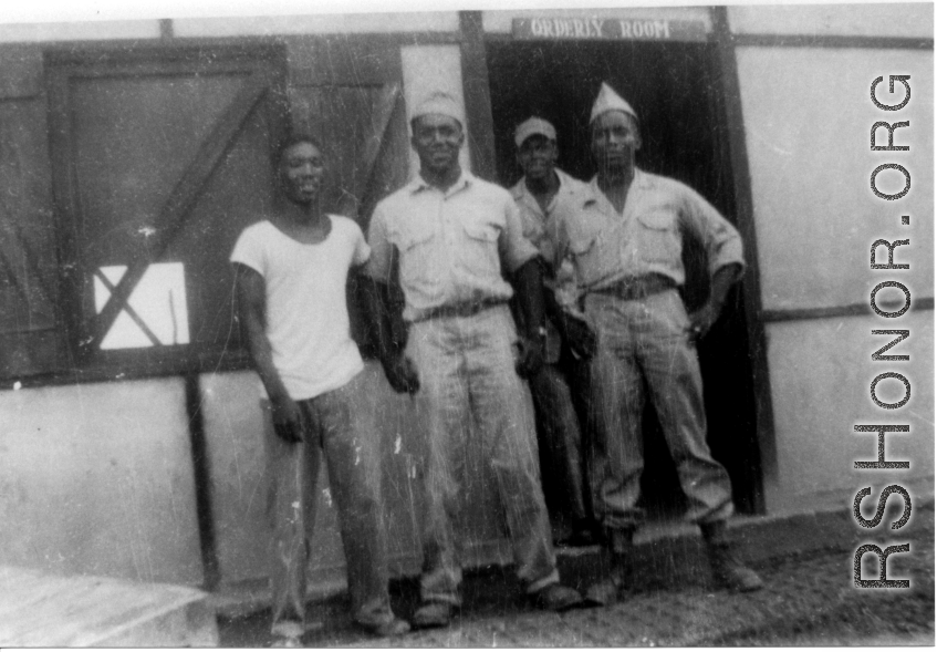 African-American servicemen stand outside the door of an "ORDERLY ROOM" in the CBI during WWII.
