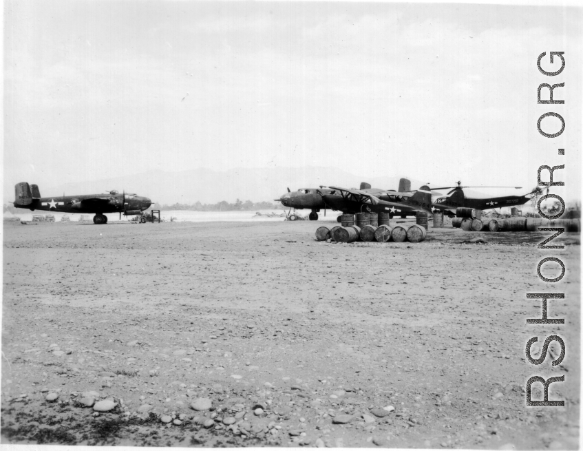 A B-25 on the left.  Spotter plane (probably an L-5) and YR-4B helicopter on the right.