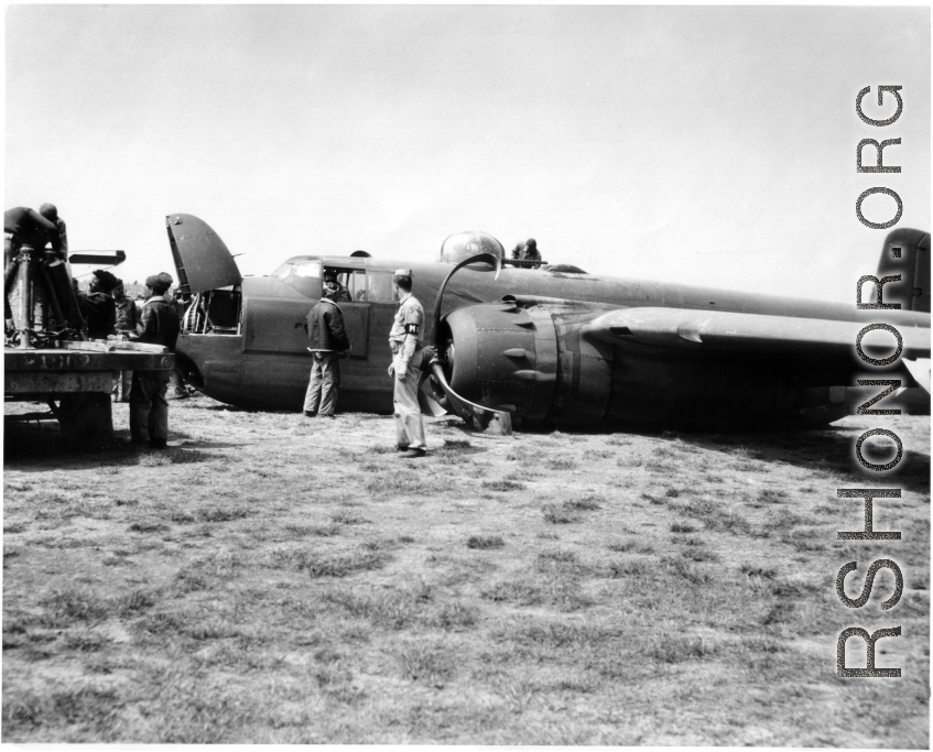 An MP hovers around a crashed B-25 Bomber in the CBI during WWII.