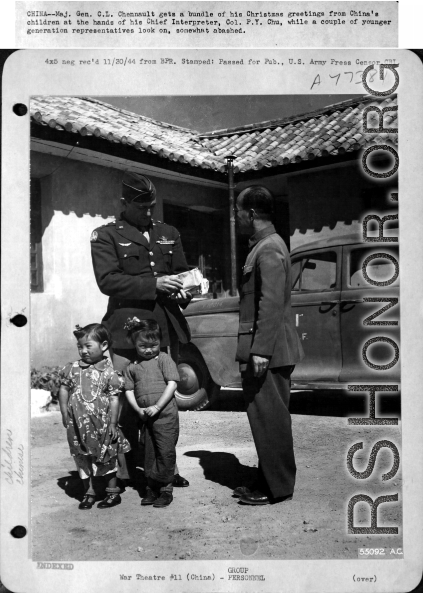 Chennault receives a bundle of Christmas greeting from China's children at the hand of his Chief Interpreter, Col. P. Y. Chu.
