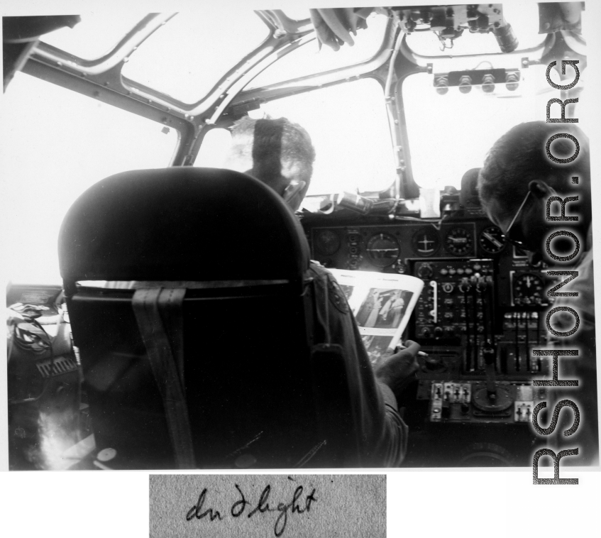 Col. Hopson reading and smoking a cigarette in B-24 cockpit in flight back to US after end of war in the CBI. This is B-24 #44-51040.