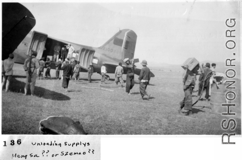 Local laborers unload supplies from an American C-47 in Mengsa or Szemao. In the CBI during WWII.
