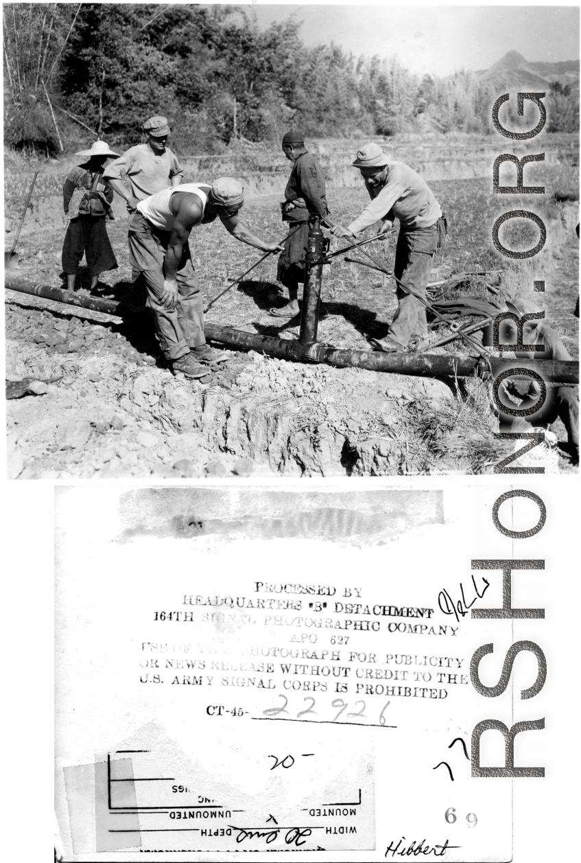 American Army petroleum engineers bend a fuel pipe with a hydraulic jack going through a farming field in SW China while local people look on. During WWII.  Photo by 164th Signal Photographic Company, provided by "Hibbert."