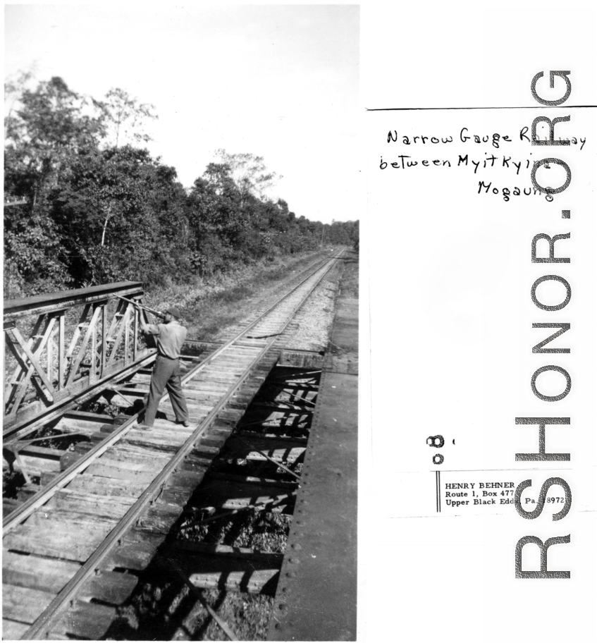 GI shoot rifle from bridge on narrow-gauge railway between Myitkyina and Mogaung, during WWII.  Photo from Henry Behner.