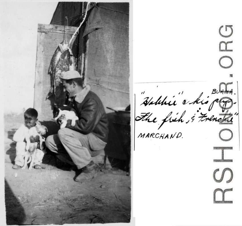 Child "Hobbie" holds a puppy, as GI looks on, also holding puppy. Burma during WWII.  Photo from Marchand.