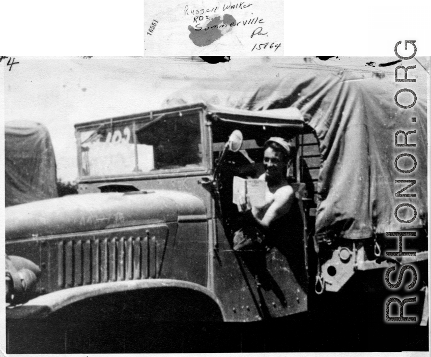 GI in driver seat of truck, with book in hand. In the CBI during WWII.  From Russell Walker.