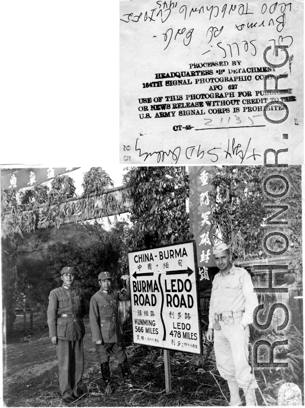 Col. Sells and two Chinese soldiers stand next to sign at the Burma-Ledo Road and Tengchong cutoff, in 1945.  Photo by T/Sgt. Syd Greenberg.