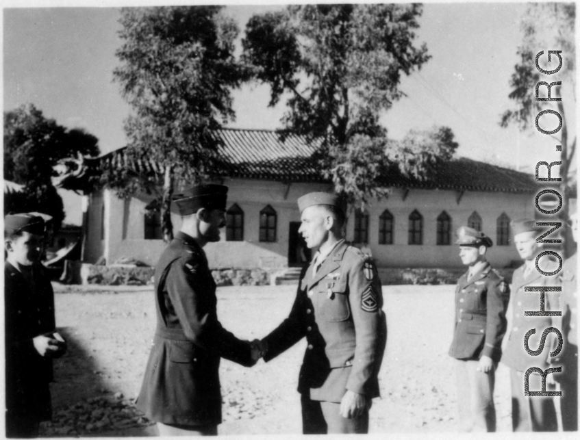 GIs shake hands during citation ceremony in China during WWII.  Image provided by Emery and Beth Vrana.