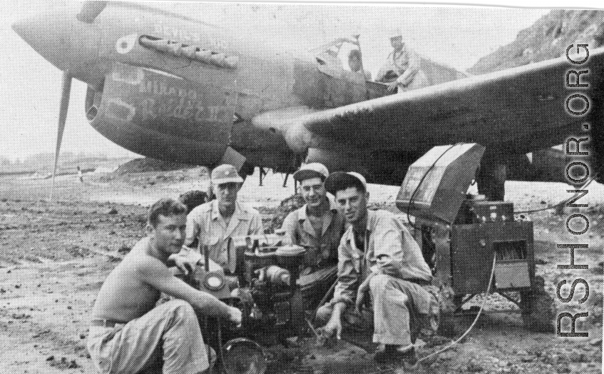 "This is another of the eight P-40's that were built from the salvage yard at Kwelin,China.The guys that are running an air speed indicator test are Art Rodriguez...Major Matthews...?...Joe Cooper. Joe was the crew chief on this project."   Notation of the nose of the plane seems to say "DEVIL'S KID" and "Mikado Raider II."