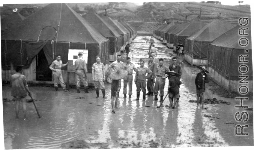 GIs and Chinese workers digging to drain the water away at a tent city of flooded living quarters at Liangshan. "This Is A Shot Of Our Gracious Living Quarters At Liangshan, China After The Creek Next To The Place Overflowed And Flooded Us Out." During WWII.