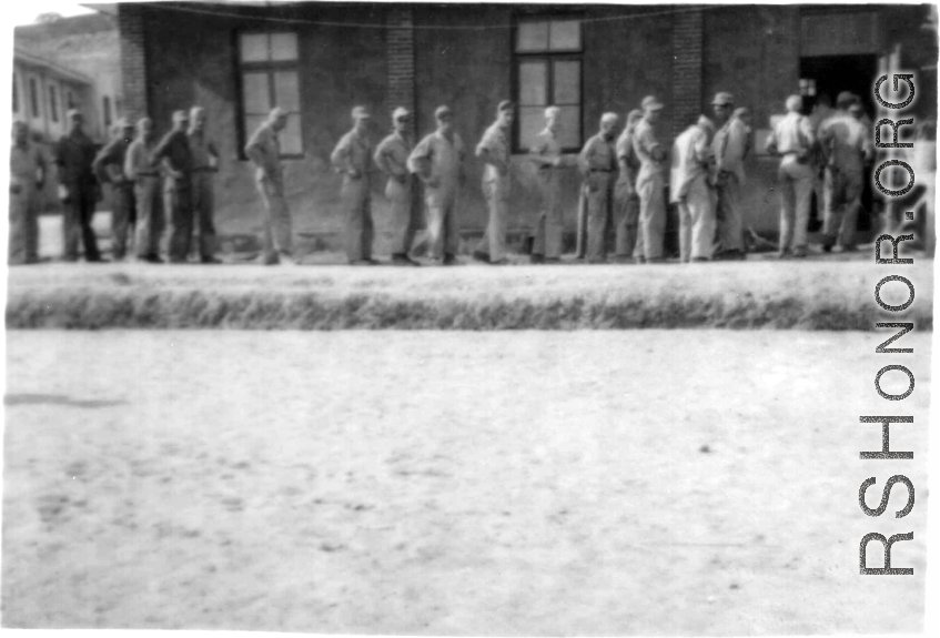 GIs at a base in China line up to go into a building.