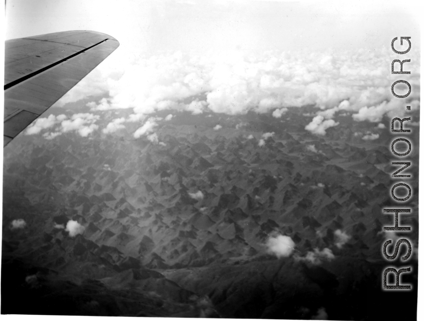 A rough karst mountain landscape as seen from a B-25 Mitchell, in SW China, or Indochina, or the China-Burma border area.  