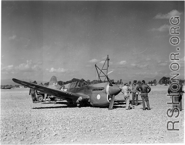 A P-40, tail #264, down on its belly in Guilin, likely a 26th Fighter Squadron "China Blitzers" P-40K. Emblem painted on cowling prior to the application of a sharkmouth."    (Thanks for additional info from jbarbaud.)  From the collection of Hal Geer.