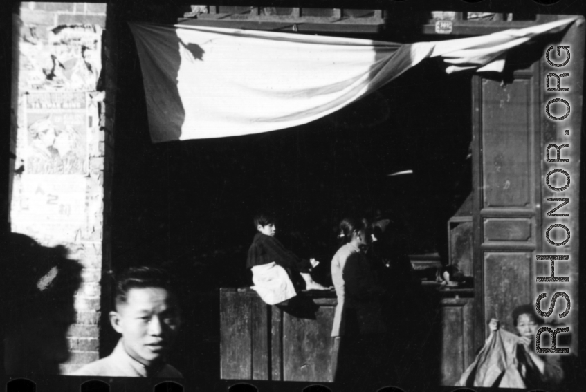 People at the door of a small retail shop in China during WWII.