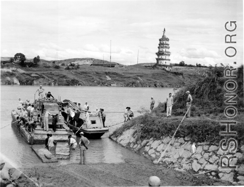 In this fascinating photo--a virtual Norman Rockwell still-life of wartime life in China--Chinese troops, American troops, and Chinese civilians cross the Xiao river (潇水) via ferry near Lingling, China, during WWII. In the background, on the east bank of the river, is the Huilong Pagoda (零陵回龙塔), which remarkably still survives, and has been restored.