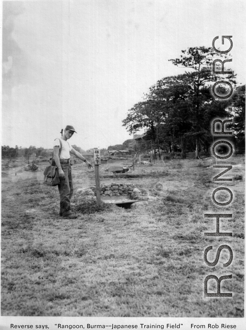 A GI points to detail at Japanese training ground in Rangoon, Burma, during WWII.