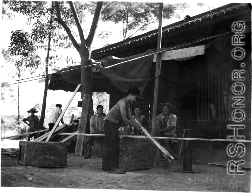 A carpenter rips lumber by hand saw in Liuzhou, China, during WWII.