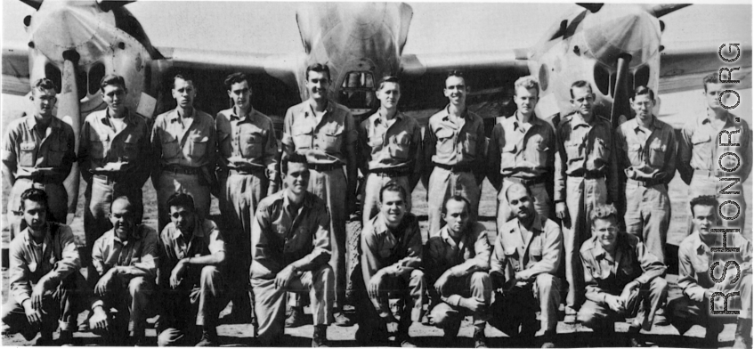 Men from the 21st Photographic Reconnaissance Squadron pose for a group shot in front of an F-5 (a variant of the P-38).