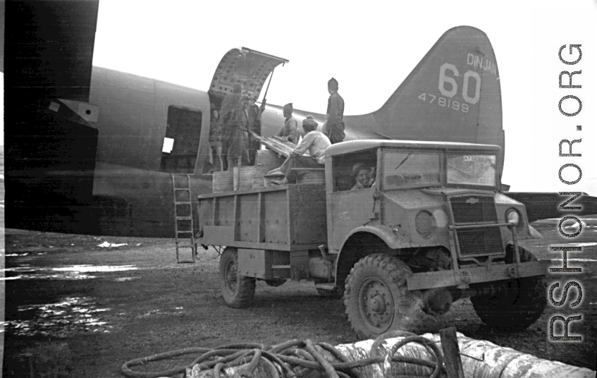 A C-46 transport plane (tail number #478199) being unloaded of fuel barrels by Chinese laborers at the air base at Luliang. During WWII.
