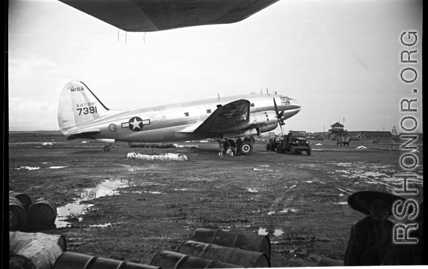 The C-46 transport tail #347391 parked at the American base at Luliang, China. The control tower can be seen in the background. During WWII.