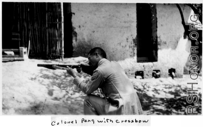 Colonel Peng, a Nationalist officer, trying out native crossbow. During WWII, in SW China.