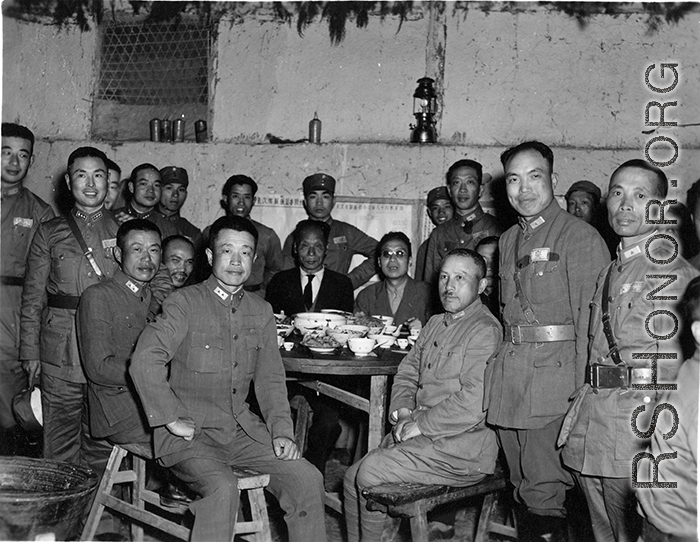 Table of local ranking Nationalist leadership during the banquet at the rally. In foreground, left, is Chinese Lt. General Du Yuming, commander of Nationalist 5th Corps (第五集团军总司令兼昆明防守司令杜聿明). Sitting turned, on right, is Gen. Wei Lihuang (卫立煌). Standing on far right is Zheng Tingji (郑庭笈), commander of the 48th Army Division (陆军第四十八师 ).  The general seated on the far left is Qiu Qingquan (邱清泉).  The two civilians seated in the back are KMT civilian officials. The one on the right is likely An Zefa (安则法), a hi