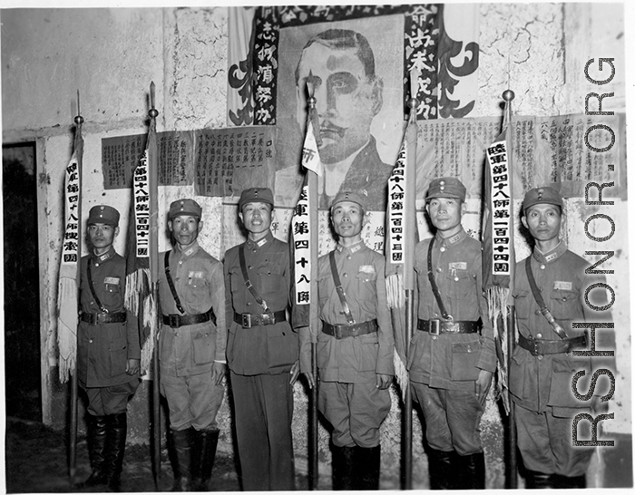 Banner bearers for different regiments of the 48th Army Division stand during rally, with 48th Army Division Zheng Tingji (郑庭笈), commander of the 48th Army Division holding the staff of the division banner. Left of him--the only person not holding a staff--is Chinese Lt. General Du Yuming, commander of Nationalist 5th Corps (第五集团军总司令兼昆明防守司令杜聿明).