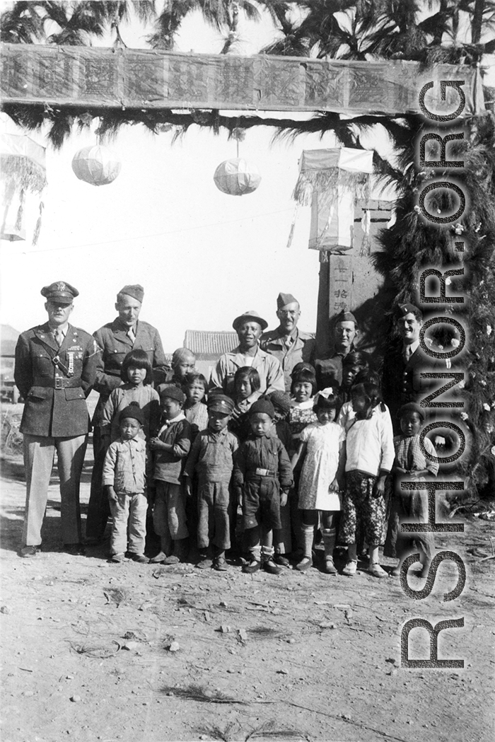 GIs and children at the decorated gate of the No. 21 Guest House (二十一招待所) in SW China (likely Yunnan) during WWII.