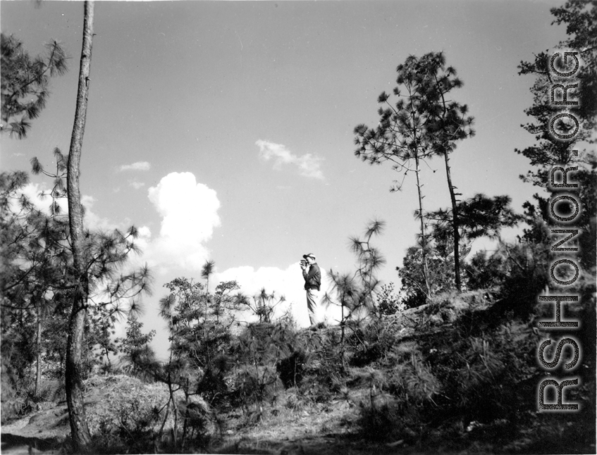 GIs adventuring among pines at Yangkai air base during WWII--The GI is using a movie camera.