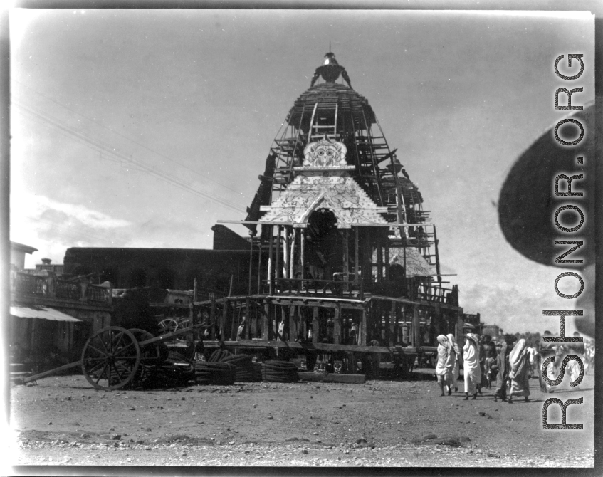 Enormous floats for a religious parade being assembled. Probably for the the Rath Yatra celebration at the large Jagannath Temple of Odisha complex (Hindu) in India.  Scenes in India witnessed by American GIs during WWII. For many Americans of that era, with their limited experience traveling, the everyday sights and sounds overseas were new, intriguing, and photo worthy.