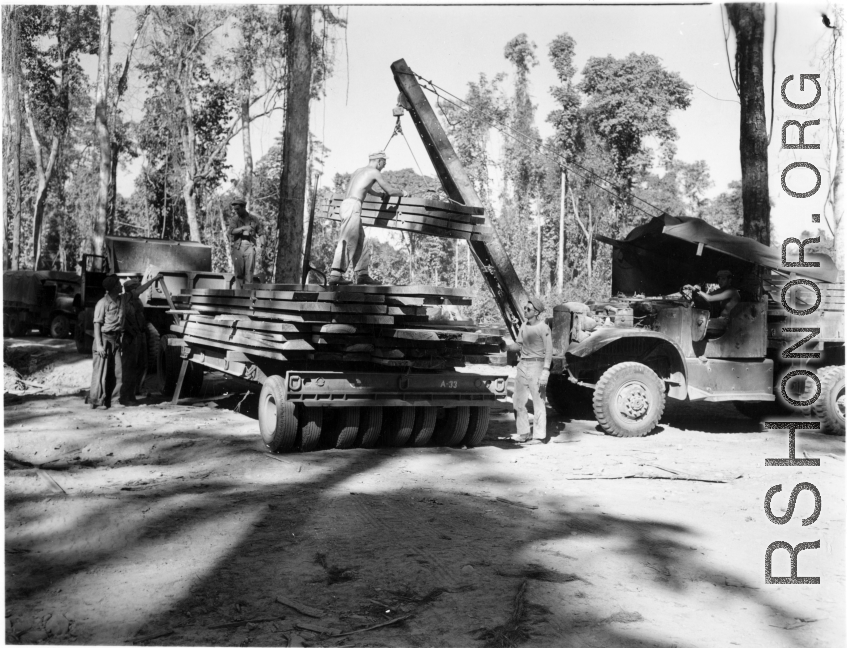 GIs load cut lumber at saw mill in Burma for transport to sites of bridge building.  During WWII.  797th Engineer Forestry Company.