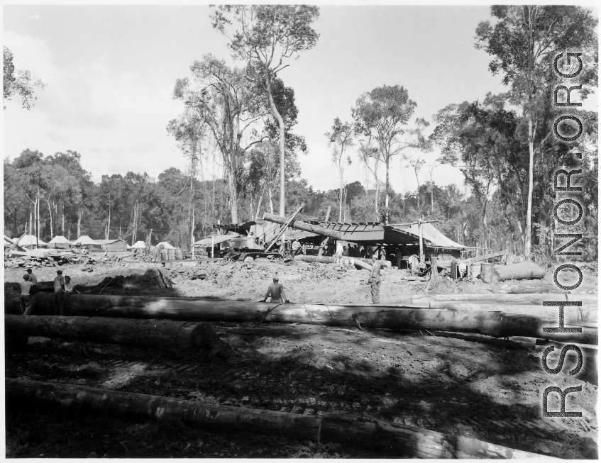 Site at the mill yard, a tracked loader feeding logs to saw line at a lumber mill of the 797th Engineer Forestry Company in Burma.  During WWII.