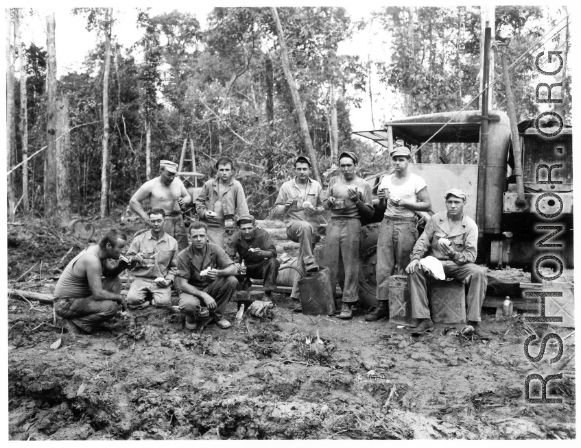 Engineers of the 797th Engineer Forestry Company pose at work site eating sandwiches, in Burma.  During WWII.