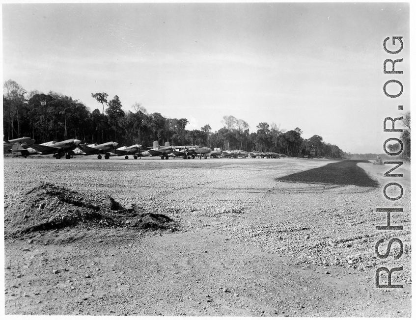 A row of tightly packed American aircraft at at an airstrip in Burma, probably in 1944, including B-25, P-40, C-47, P-47, etc. Apparently they were not concerned about Japanese air raids given the tight layout.  Aircraft in Burma near the 797th Engineer Forestry Company.  During WWII.