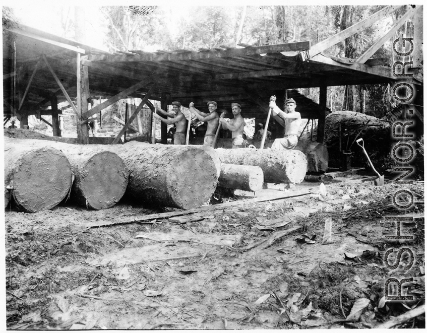 Wranging mud-covered logs towards saw with cant pikes at a lumber mill of the 797th Engineer Forestry Company in Burma.  During WWII.