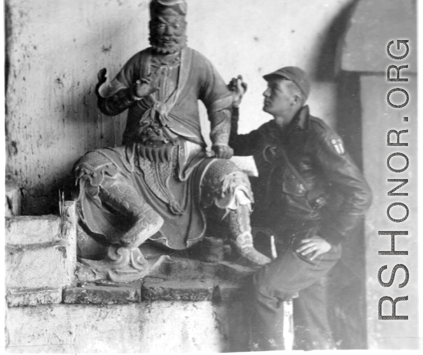 American flyer explore temple and looks at statue at Chanyi (Zhanyi), during WWII.