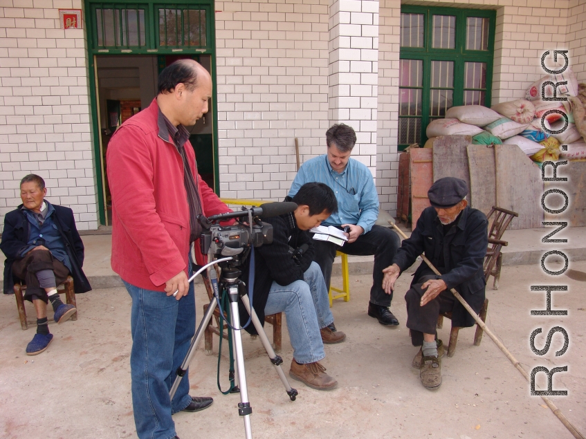 Mr. SU, and Mr. LUCAS interview old timers in the village.  This home is only a few meters from the pond where the remains rest.  Mr. HUANG Xiling video tapes.