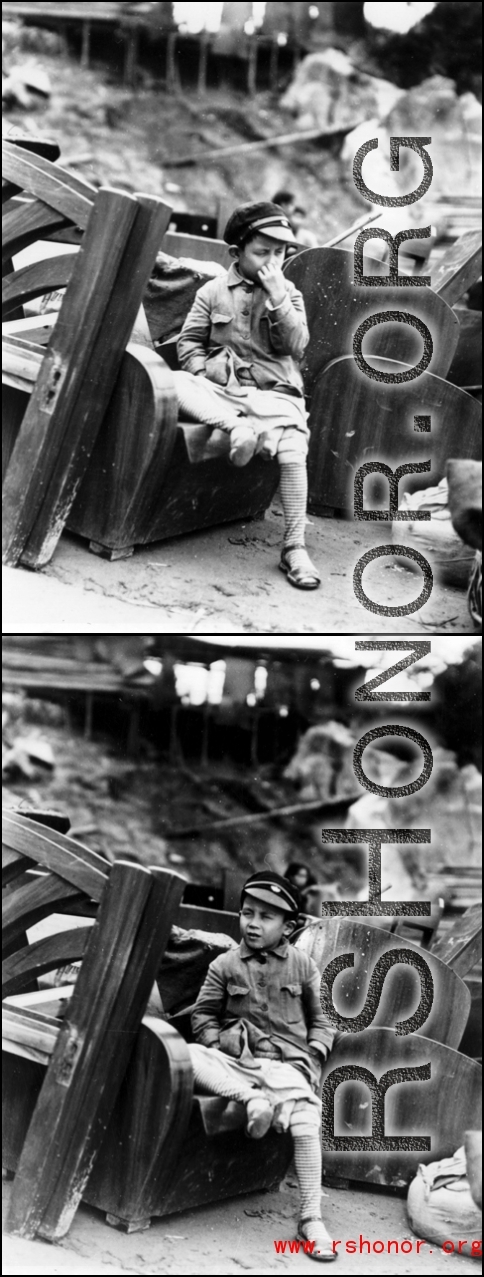 A young boy sits among discarded furniture, presumably items that had ultimately been discarded, during their flight in the face of the Japanese Ichigo campaign in fall 1944.